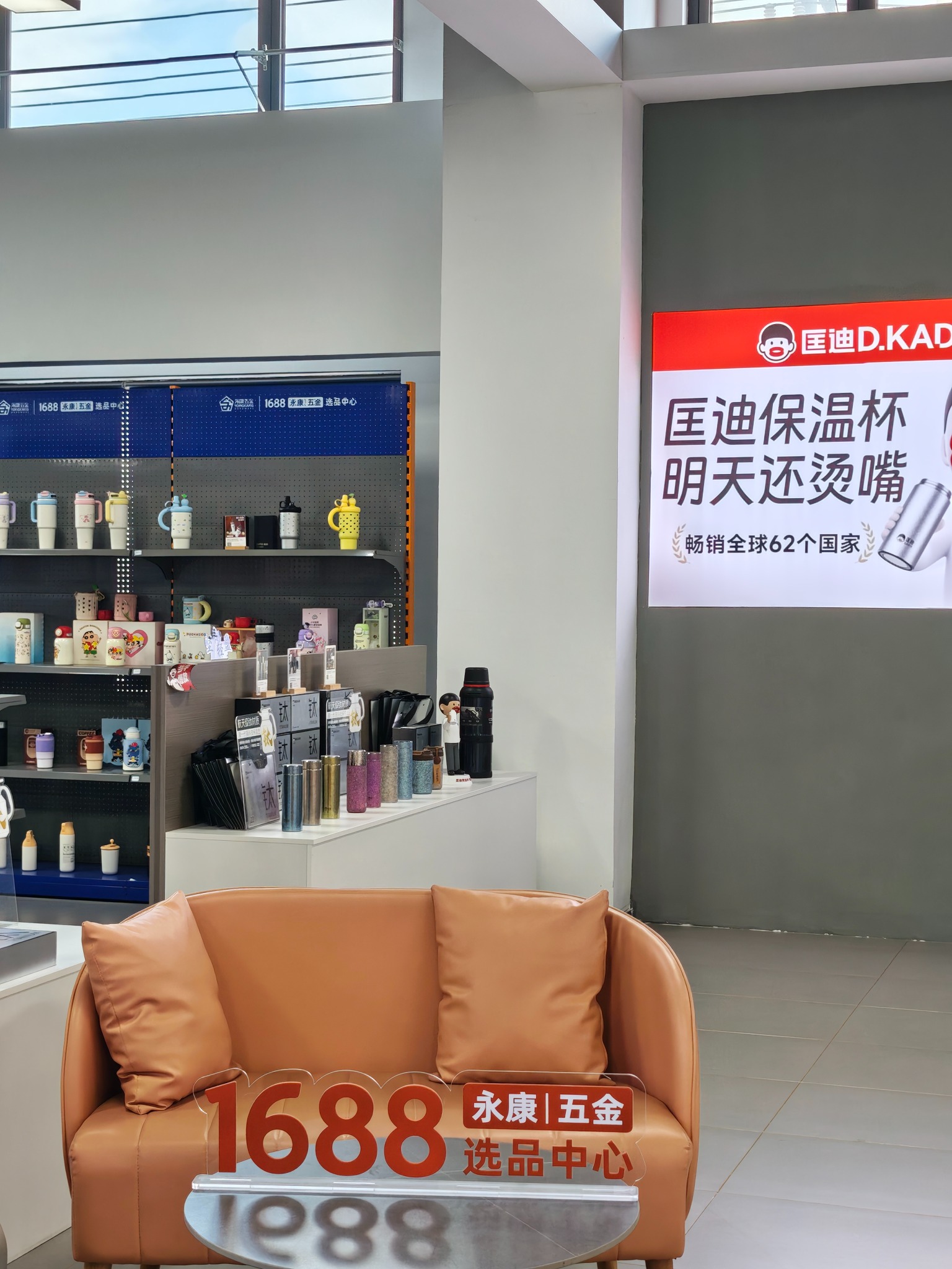Real selection-center drinkware display beside an orange sofa and wall signage